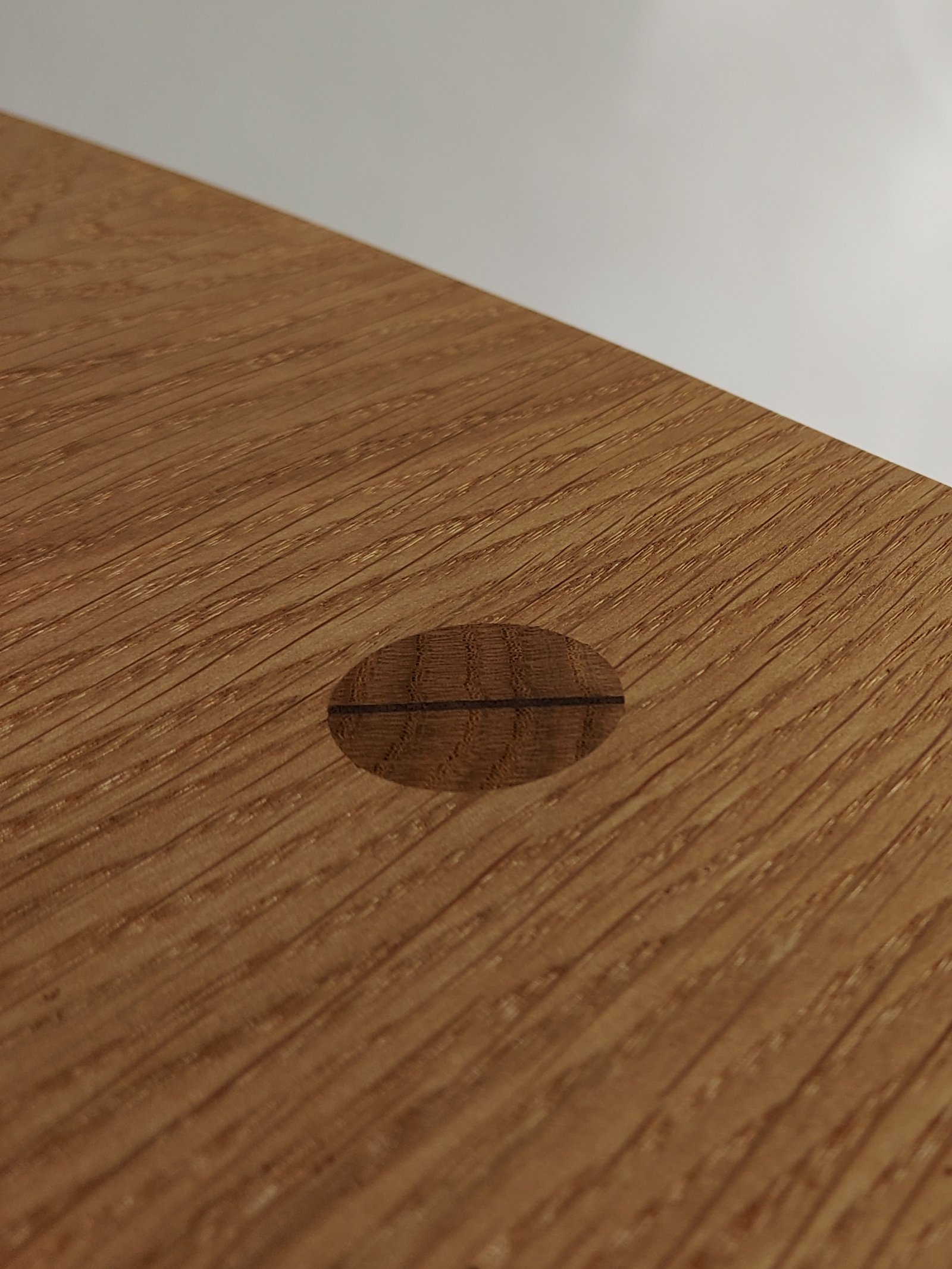 Close-up of a circular wedged joint in a wooden tabletop