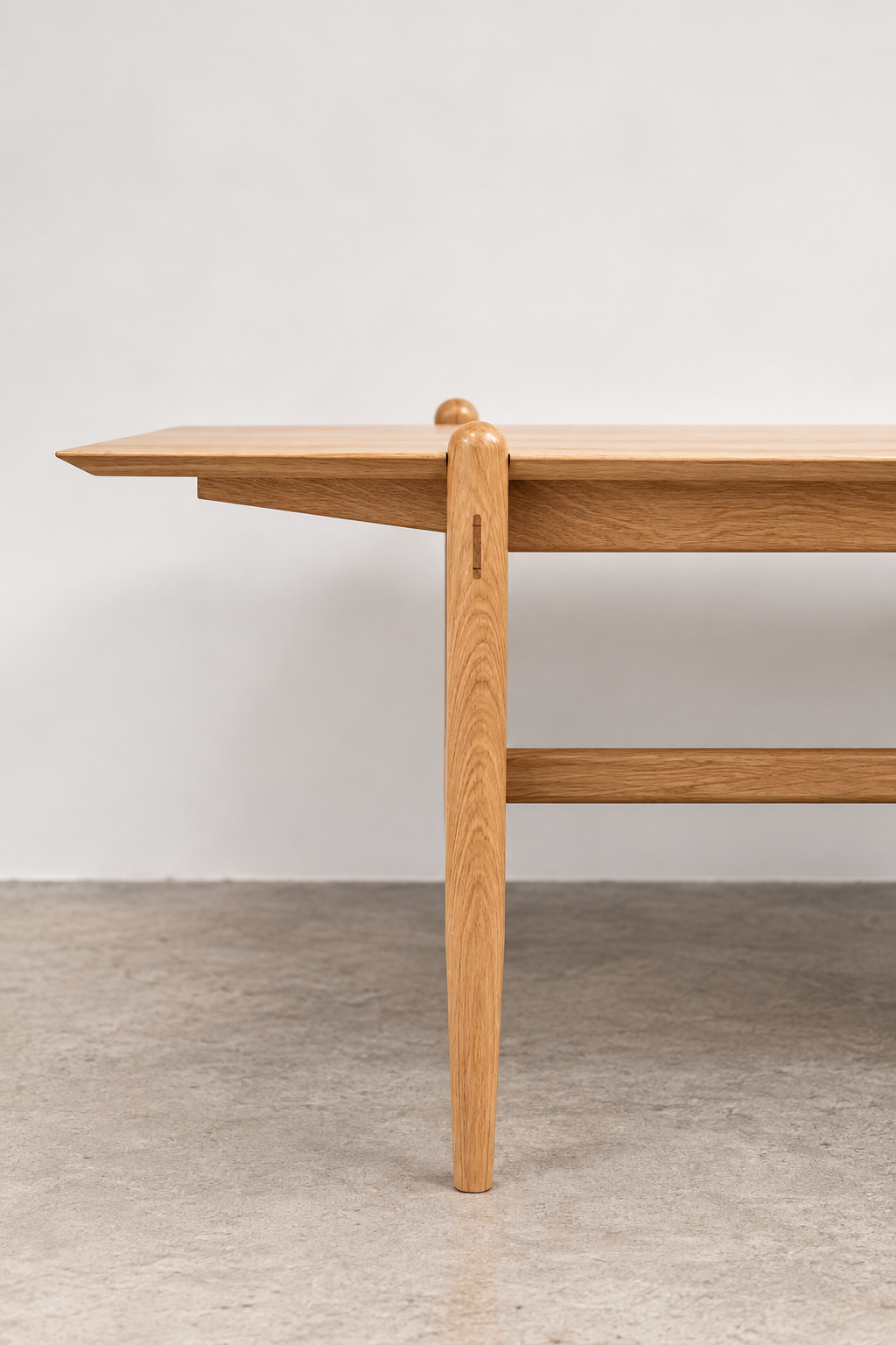 Side view of the Shibui Table rounded leg and cross stretcher
