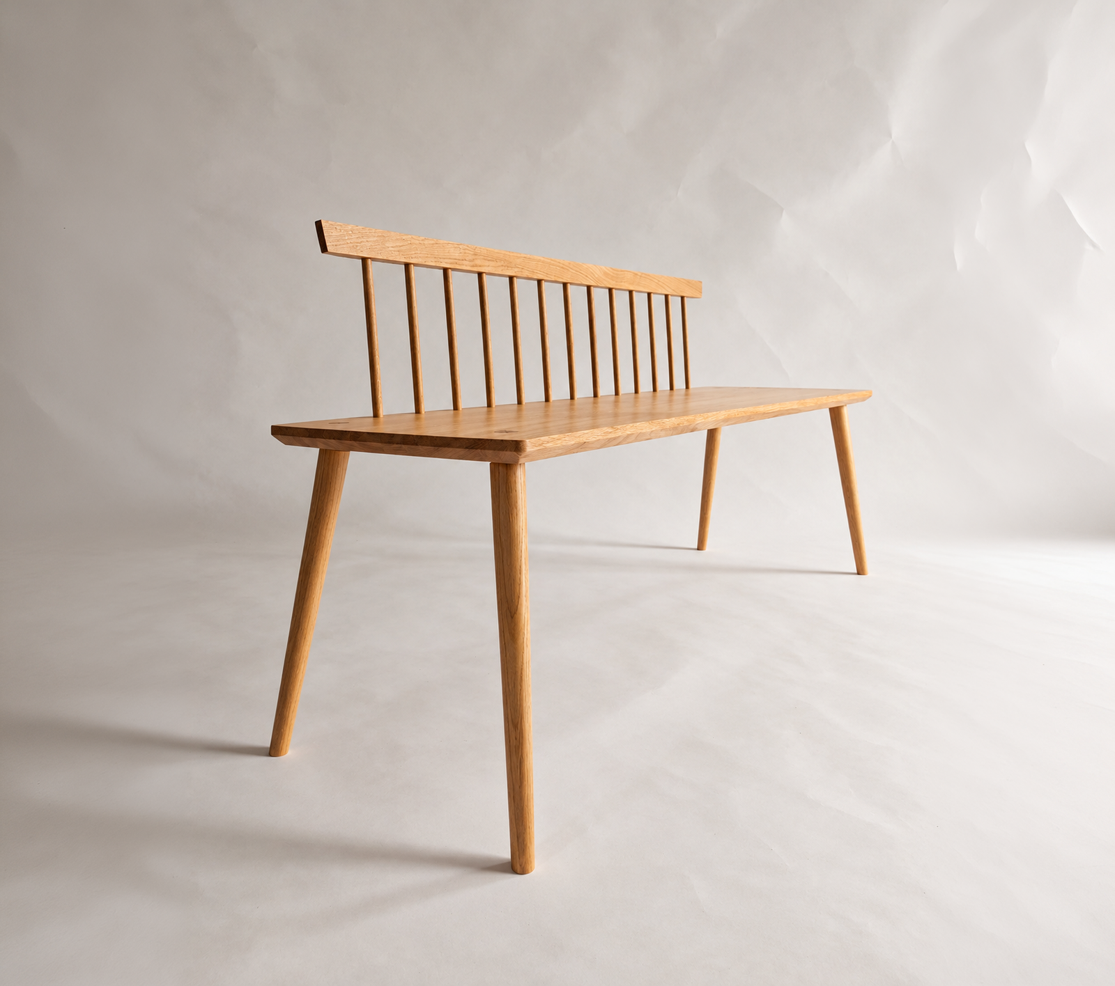 Three-quarter view of the Nokori Bench with timber spindle back