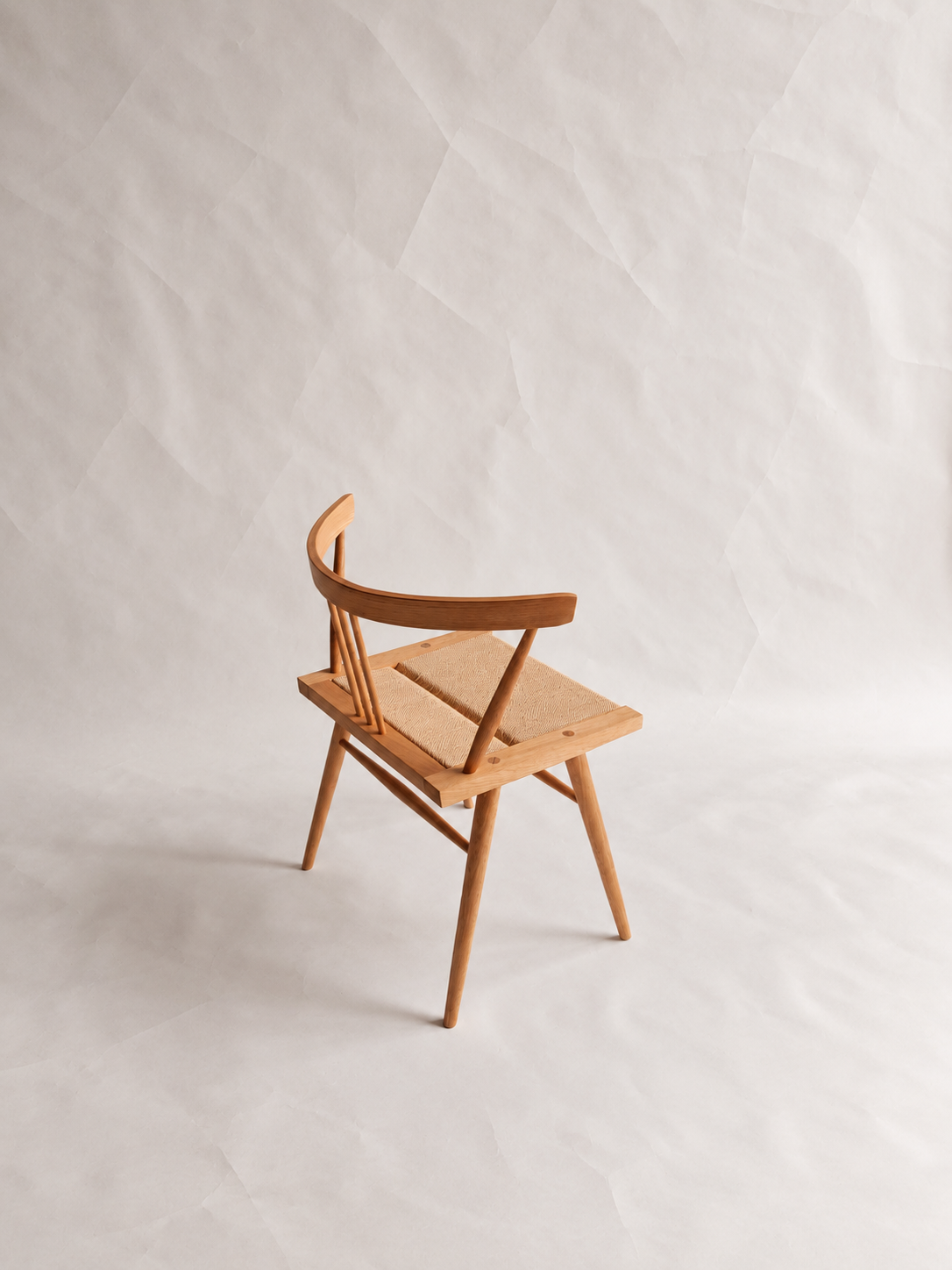 Three-quarter view of the Shibui Chair with curved backrest and woven seat