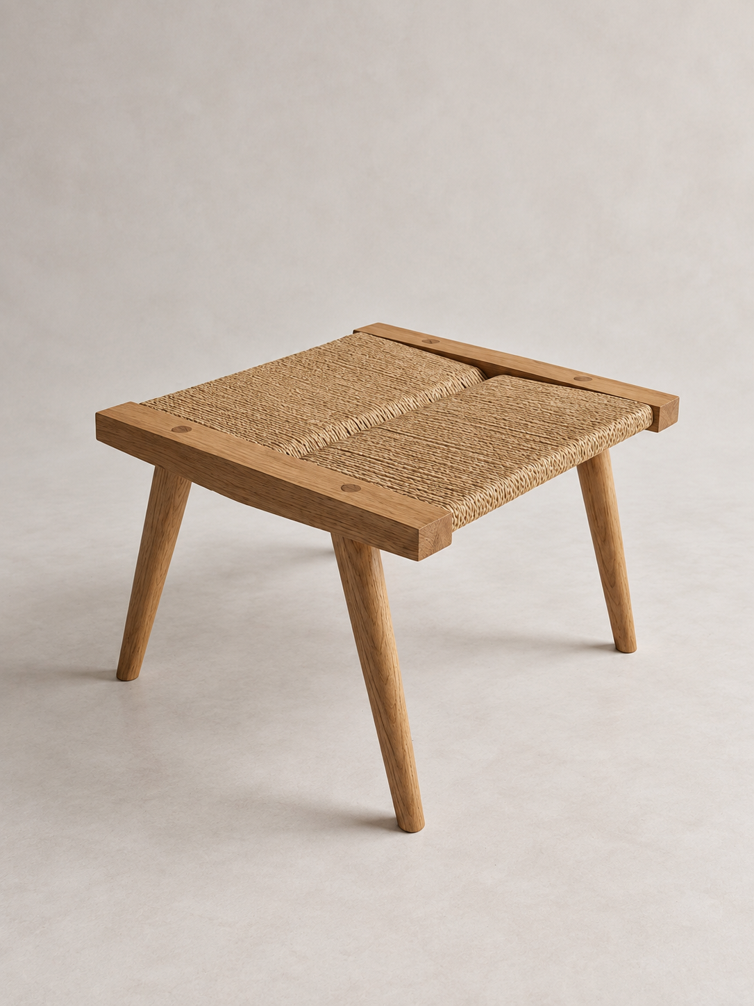 Three-quarter view of the Shibui Footstool with splayed legs