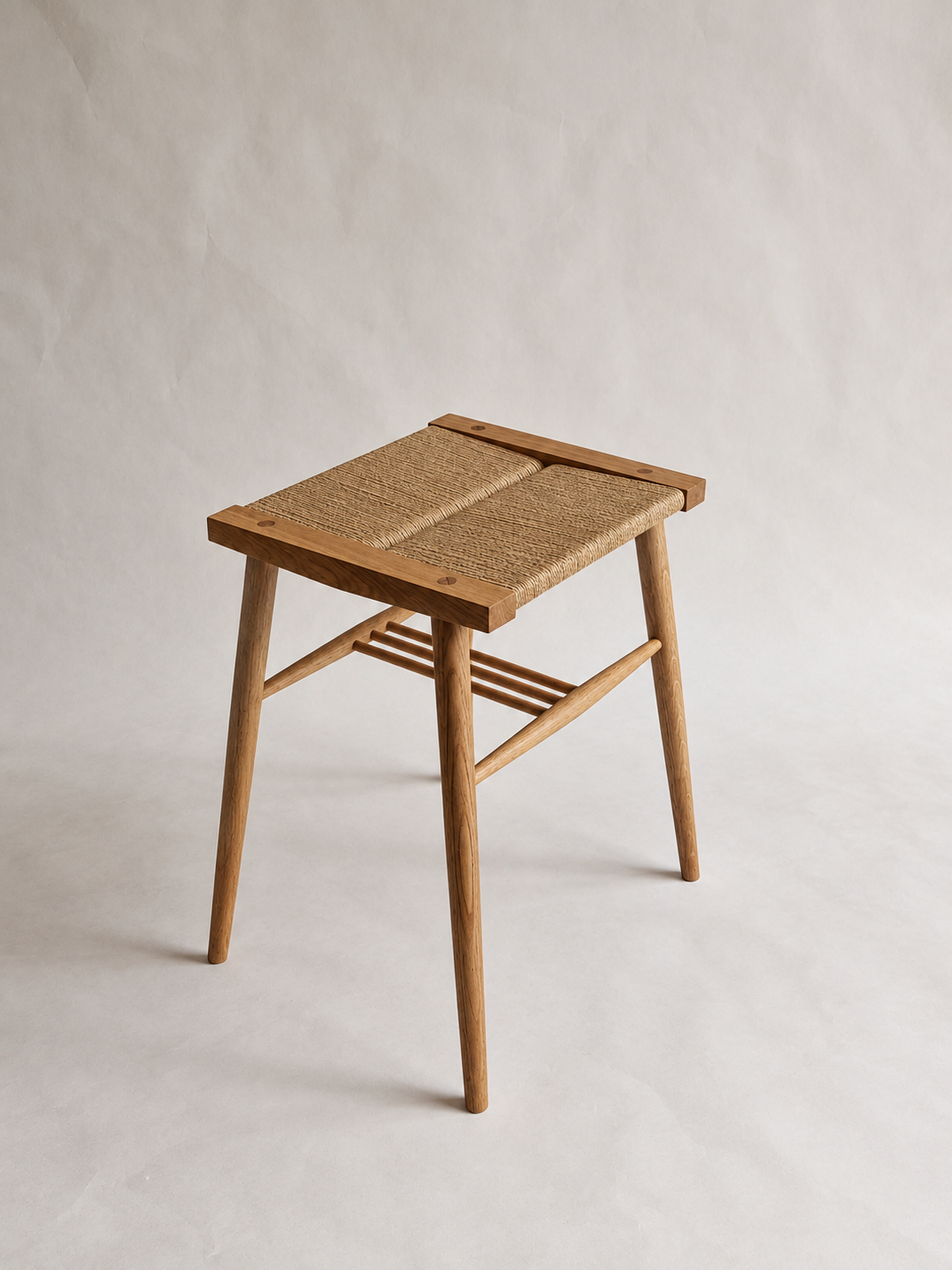 Three-quarter view of the Shibui Stool with woven seat and stretchers