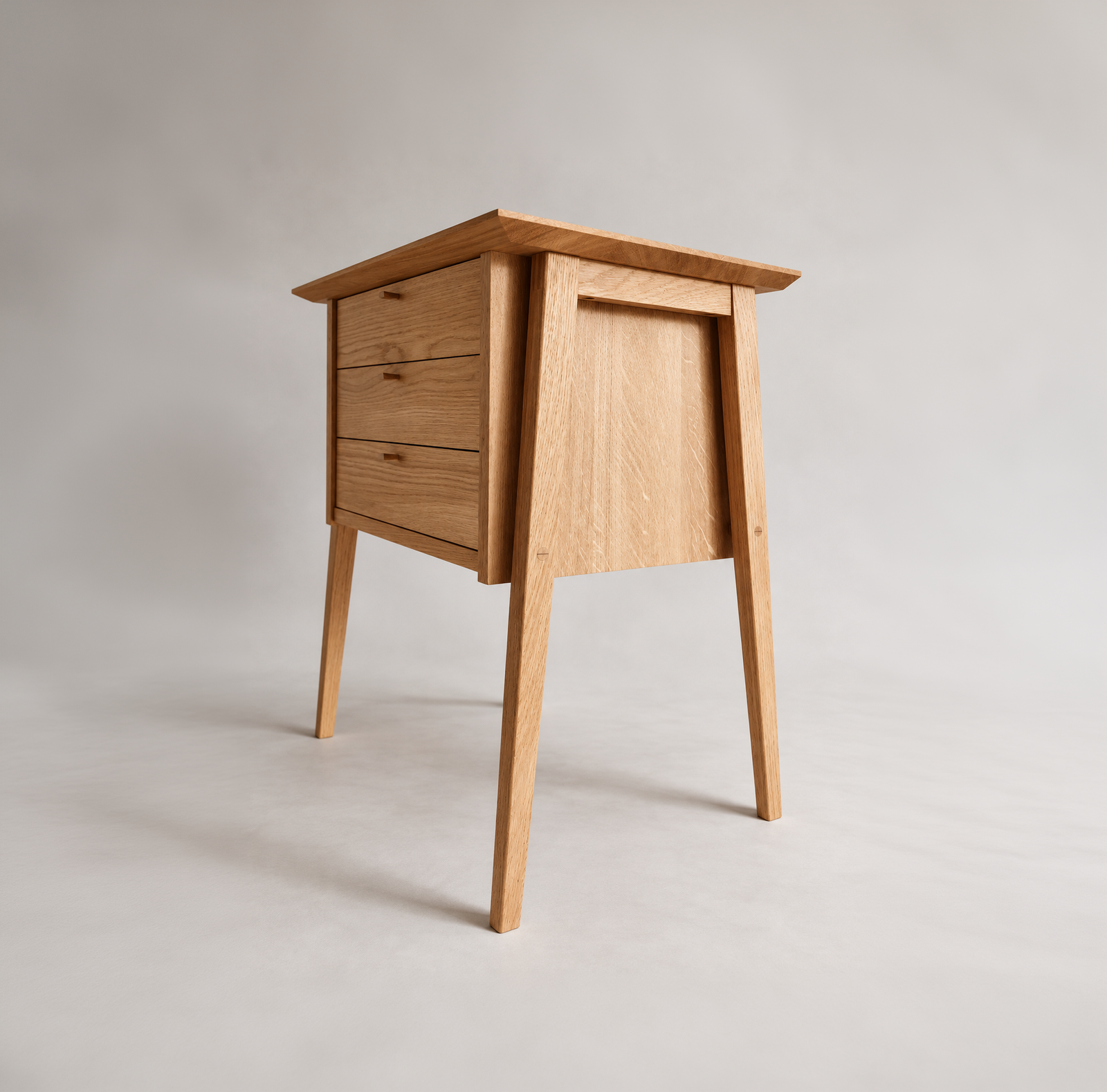 Three-quarter view of the Yugen Side Stand with three drawers and tapered legs