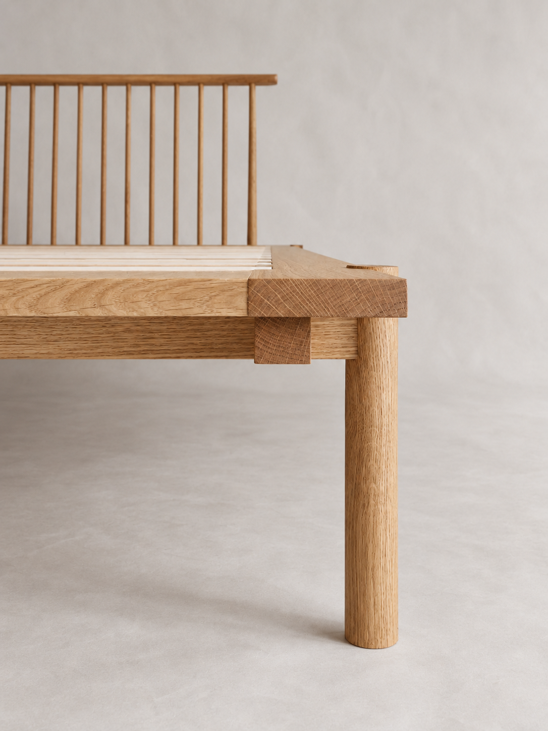Yatta Bed foot rail and leg with the spindle headboard behind