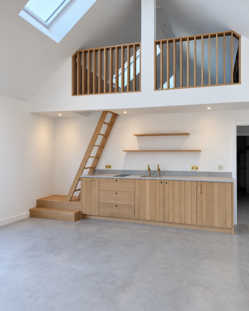 Pool house kitchen beneath a timber mezzanine and ladder