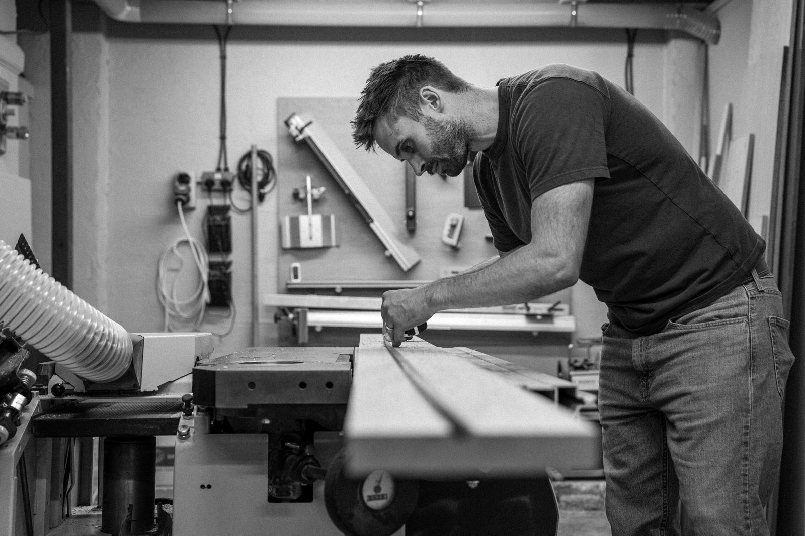 Furniture maker marking a timber board at a workshop machine