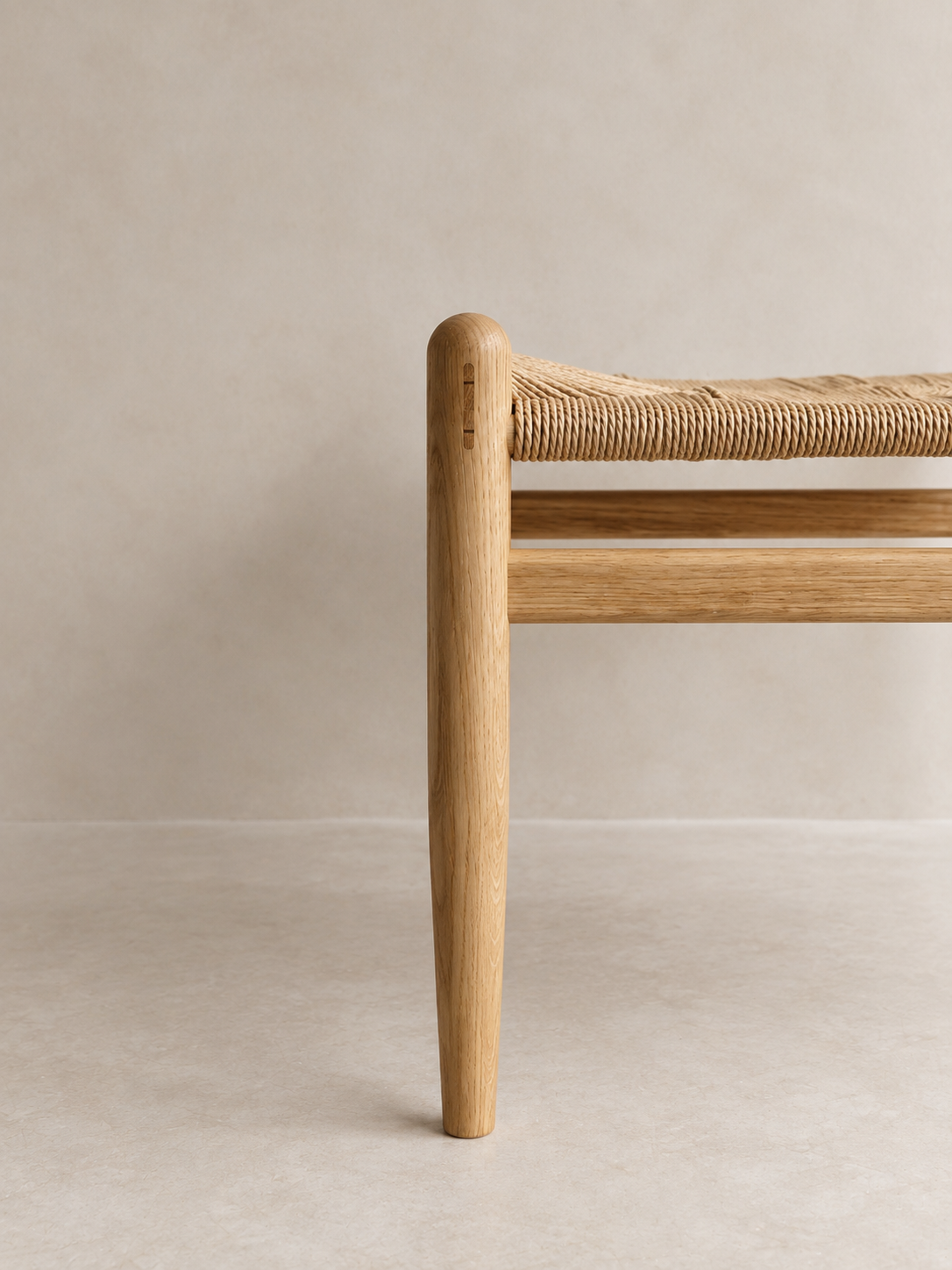 Side view of the Pett Stool with woven seat and timber stretchers